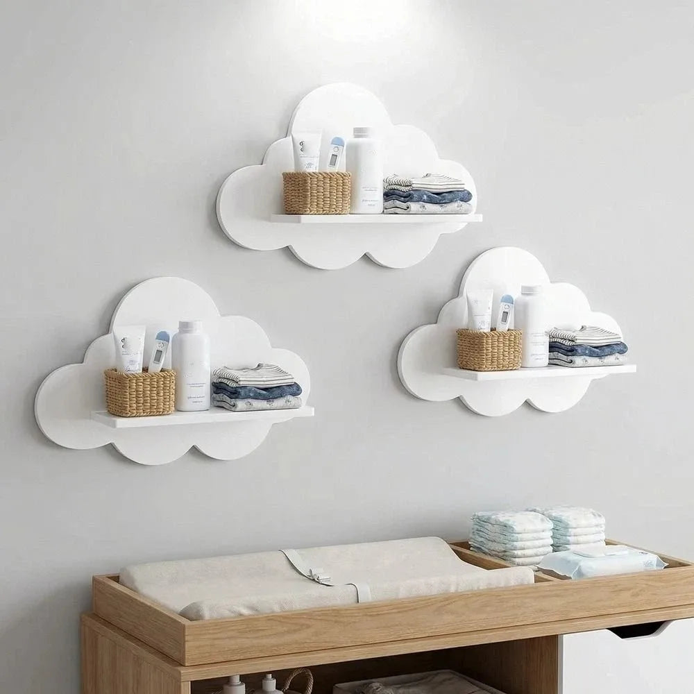 Three white cloud-shaped wooden wall shelves, 25x20 cm, holding baby items above a changing table.