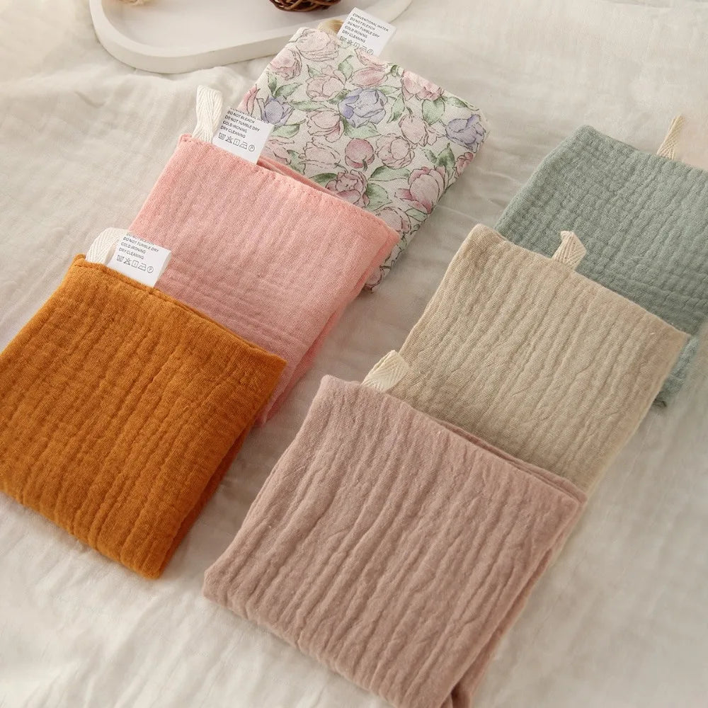 Soft, multi-colored 100% cotton gauze baby washcloths in various pastel shades and one floral print.