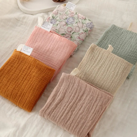 Soft, multi-colored 100% cotton gauze baby washcloths in various pastel shades and one floral print.