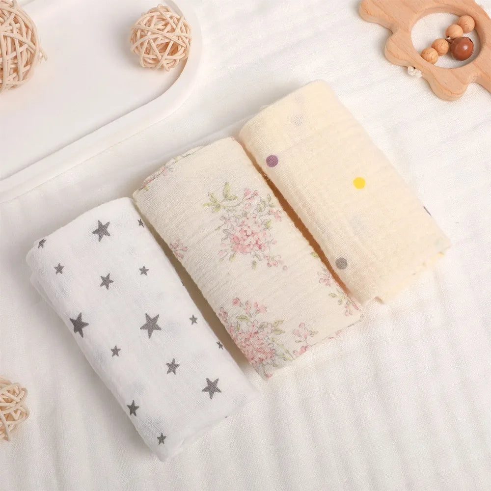 Soft cotton gauze baby towels: white with gray stars, floral, and yellow with colorful dots.