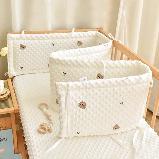 Soft white polyester baby crib bumper with cute embroidered bear and leaf cartoon designs.