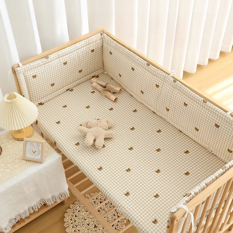 Beige gingham crib bumper and sheet set with cute bear embroidery.