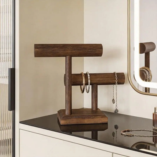 Elegant dark wood two-tier jewelry organizer stand for watches, bracelets, and necklaces on a vanity.