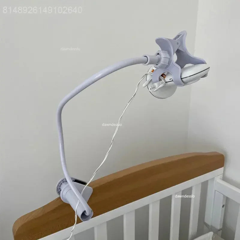 White flexible baby monitor arm with clamp, attached to a wooden crib.