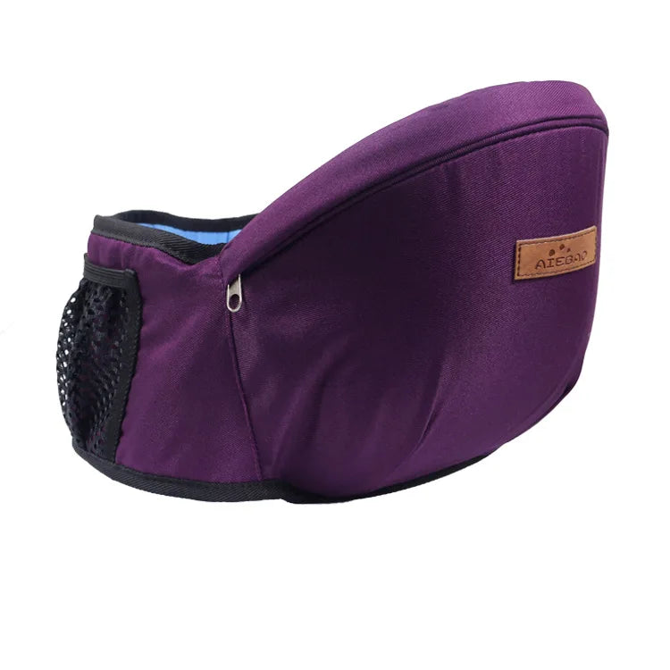 Ergonomic purple baby hip seat carrier with adjustable strap, mesh pocket, and brown leather-like logo tag.