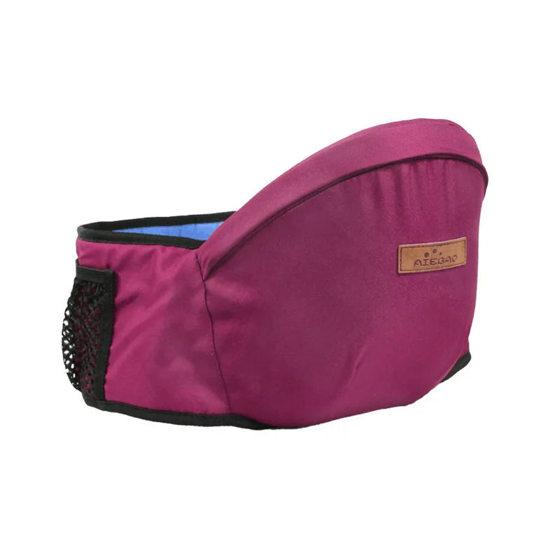 Ergonomic magenta baby hip seat carrier with adjustable strap, mesh pocket, and brown leather-like logo tag.