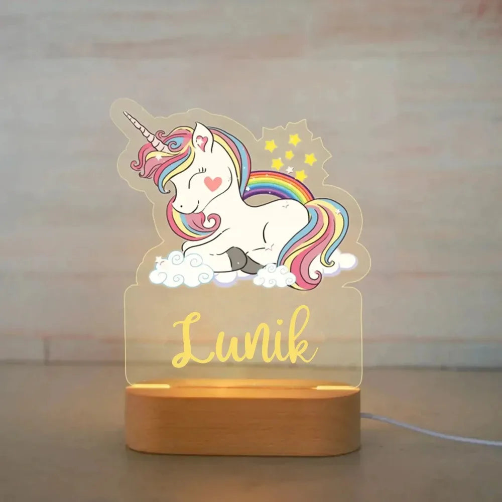 Personalized unicorn night light with rainbow mane, wood base, and custom name "Lunik" in yellow.
