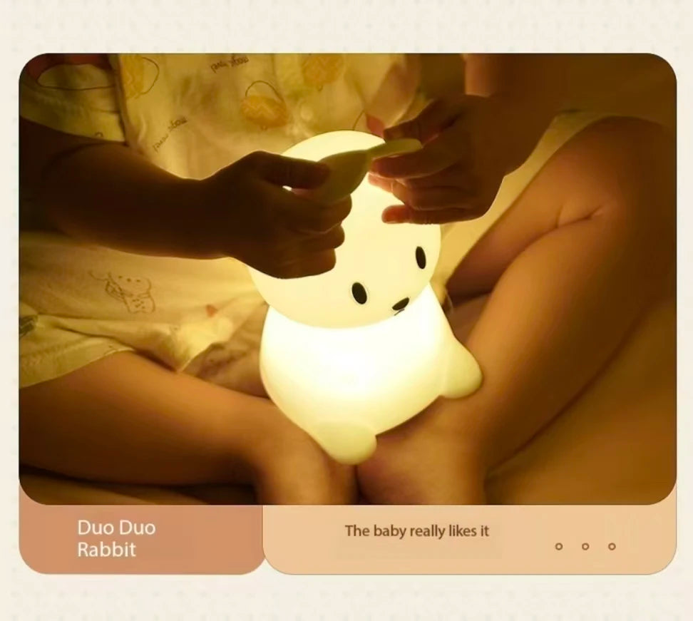 Silicone rabbit night light with touch sensor, glowing warmly on a child's lap.