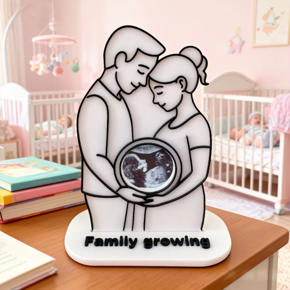 White plastic ultrasound photo frame featuring a couple holding a baby scan, with "Family growing" text.