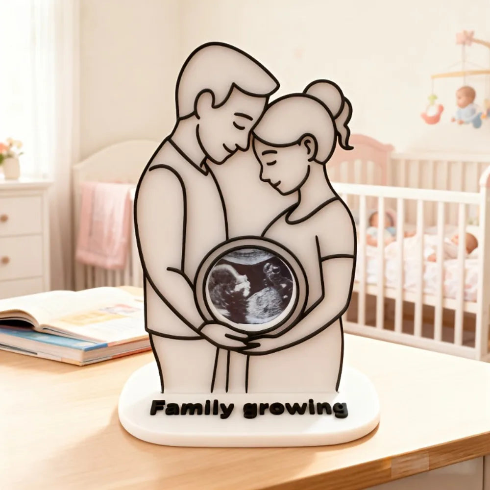 White acrylic ultrasound photo frame with a couple silhouette holding a baby scan, on a "Family growing" base.