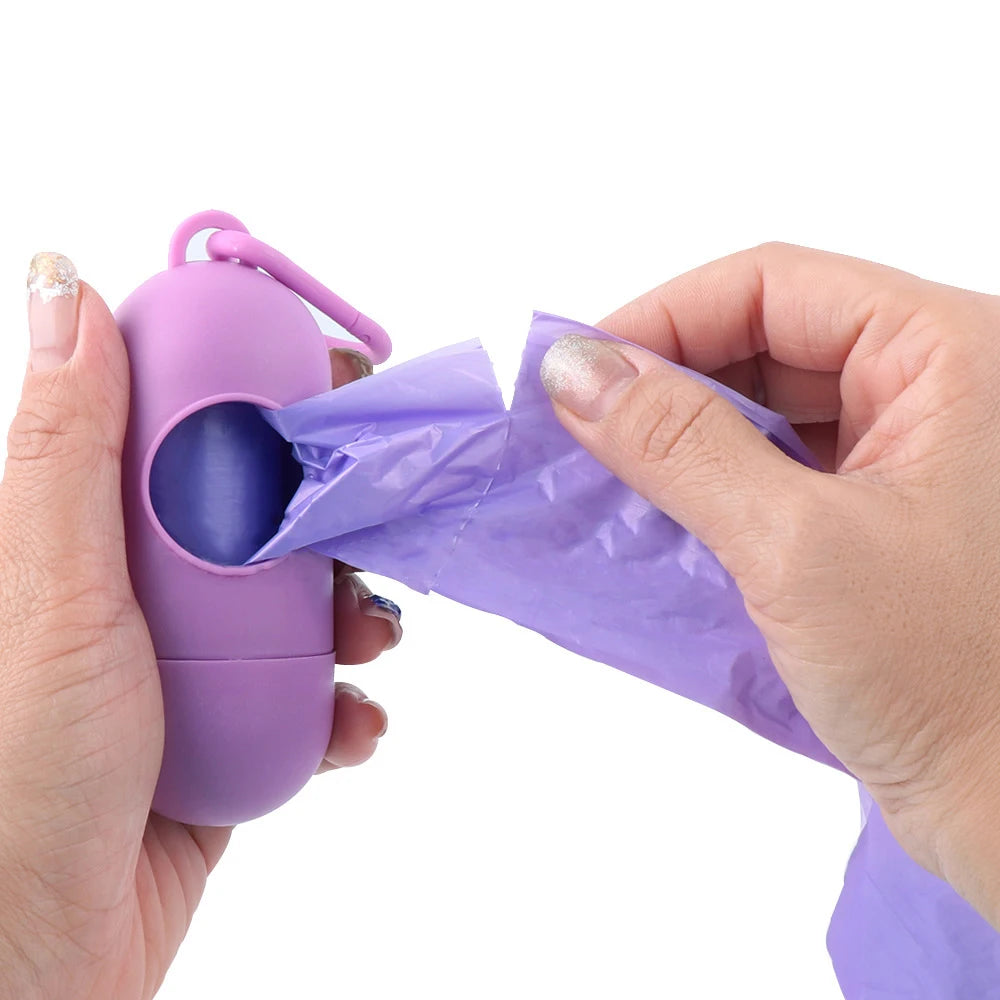 Purple capsule-design portable waste bag dispenser with a roll of bags, held by hands.