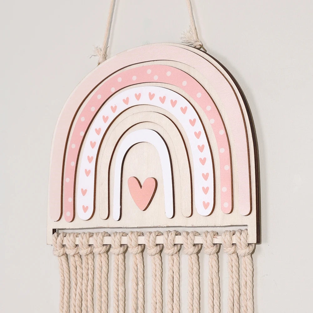 Pink wooden rainbow wall hanger with heart details and macrame for hair accessories.