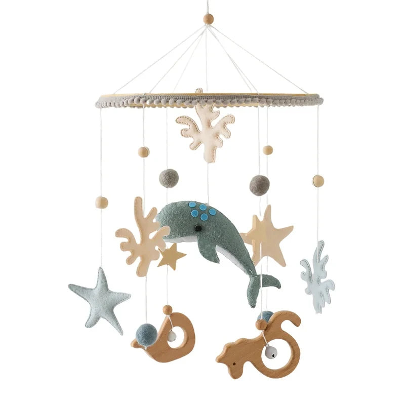 Wooden crib mobile with felt sea creatures, stars, and natural wood elements.