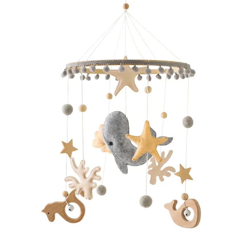 Wooden crib mobile with felt sea animals, stars, and natural wood elements.