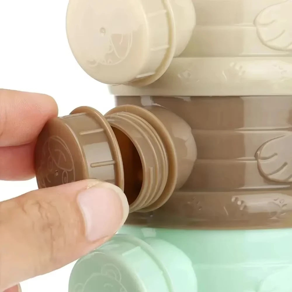 Hand opening a modular, stackable baby formula dispenser in beige, brown, and mint green PP plastic.