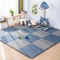 Blue and gray interlocking EVA foam puzzle play mat for babies in a child's room.