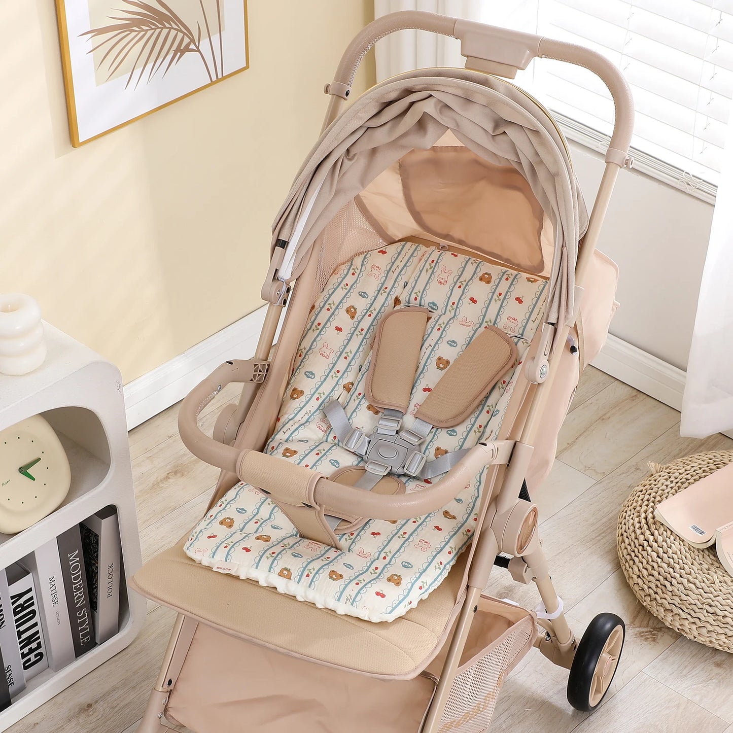 Beige baby stroller with a soft, patterned seat cushion featuring bears and clouds, and a 5-point harness.
