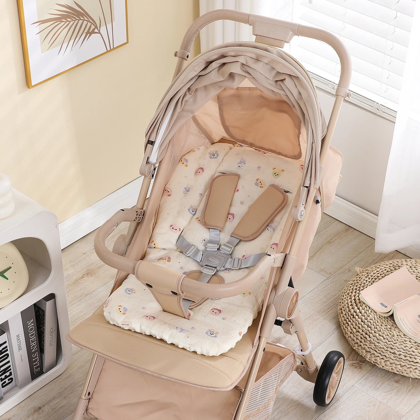 Beige baby stroller with a soft, padded seat cushion featuring a cute bear pattern.