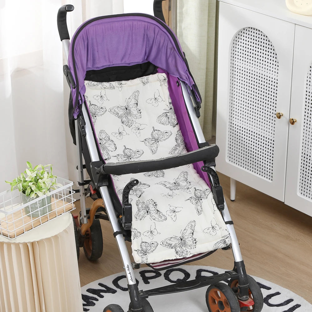 White cotton stroller cushion with black butterfly print, fitted in a purple stroller.