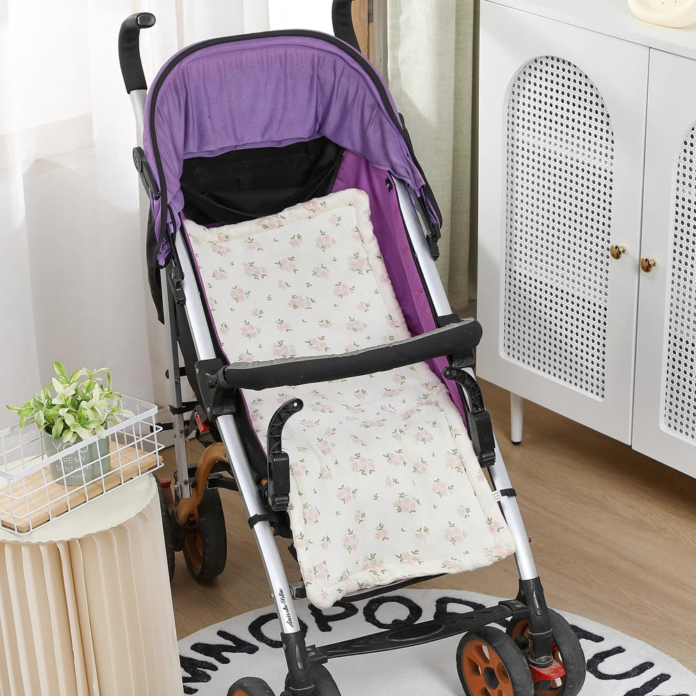 Soft white stroller cushion with pink floral print, fitted in a purple baby stroller.