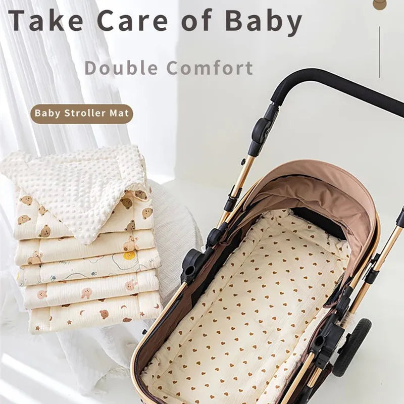 Beige baby stroller mat with brown heart pattern, next to stacked quilted mats with animal prints.