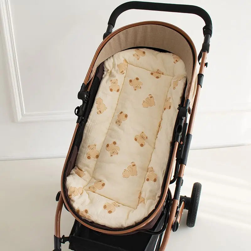 Soft beige cotton stroller cushion with brown teddy bear print, offering comfortable universal fit.