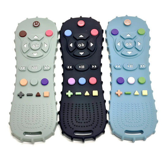 Three silicone remote control teethers in gray, black, and blue with colorful buttons and textured backs.