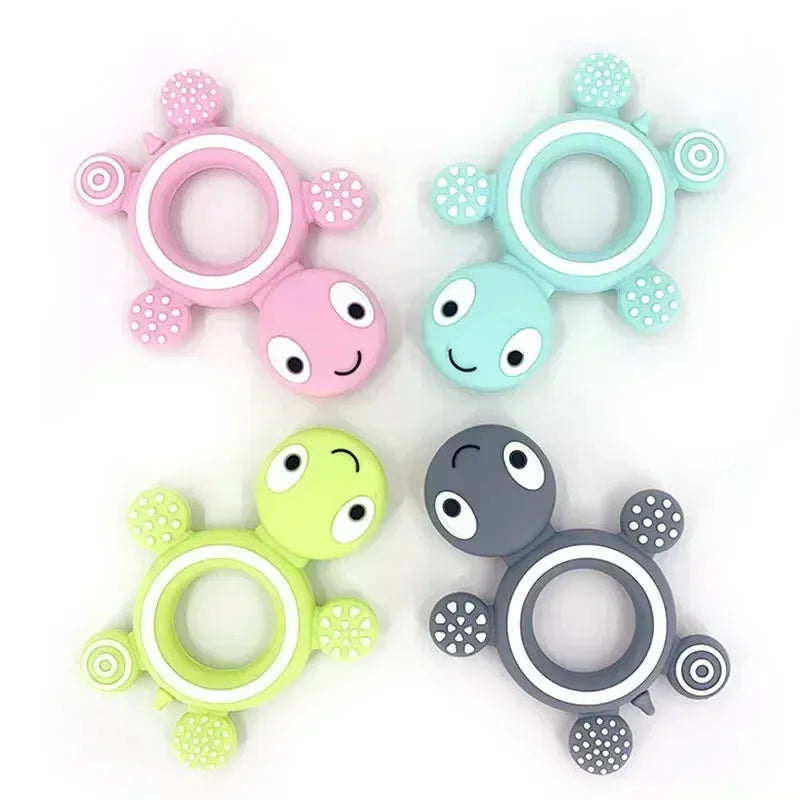 Four soft silicone turtle teethers in pink, blue, green, and gray with textured rings and feet.