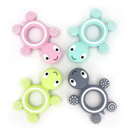Four soft silicone turtle teethers in pink, blue, green, and gray with textured rings and feet.