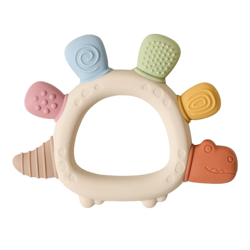 Beige silicone dinosaur teether with colorful textured spikes for soothing baby gums.