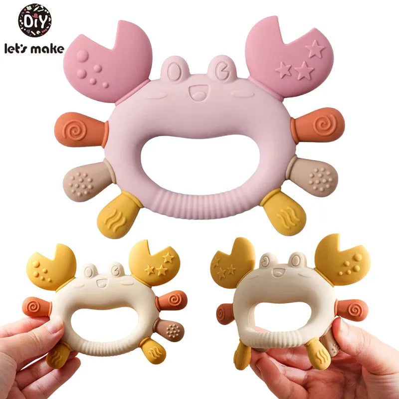 Pink and beige crab silicone teether for babies, with textured claws and legs.