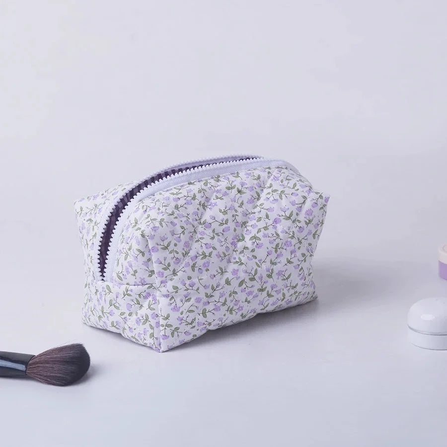 Quilted floral makeup bag with purple zipper, ideal for travel and daily use.