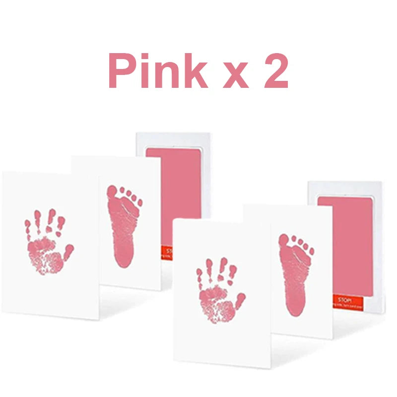 Pink baby hand and foot print kit with two ink pads and four white cards for inkless impressions.
