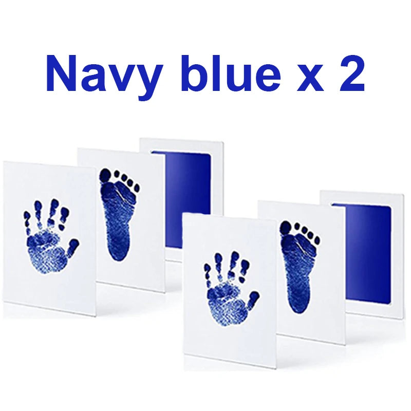 Two navy blue inkless baby handprint and footprint kits, each with a white frame and clear ink pad.