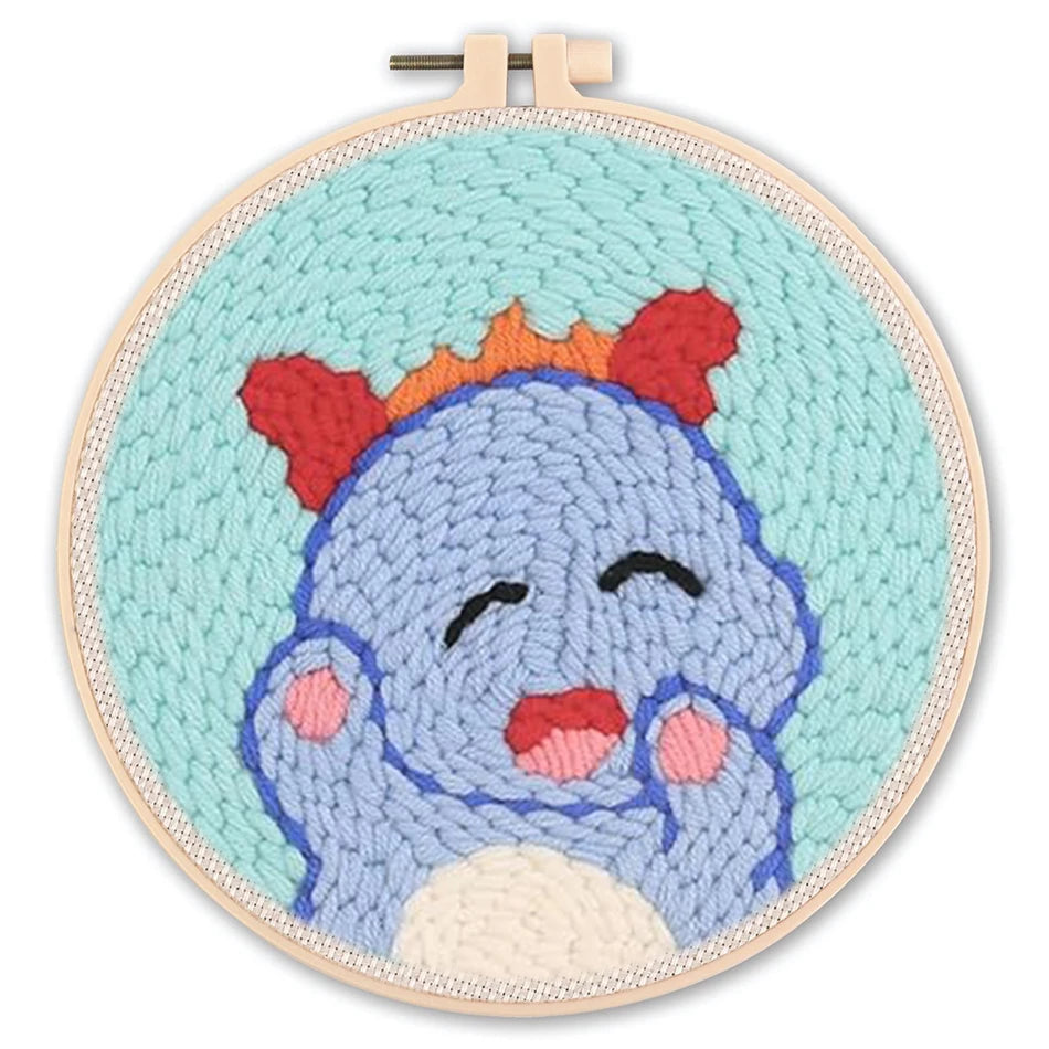 Punch needle embroidery kit featuring a cute blue monster with red ears on a light blue background in a hoop.