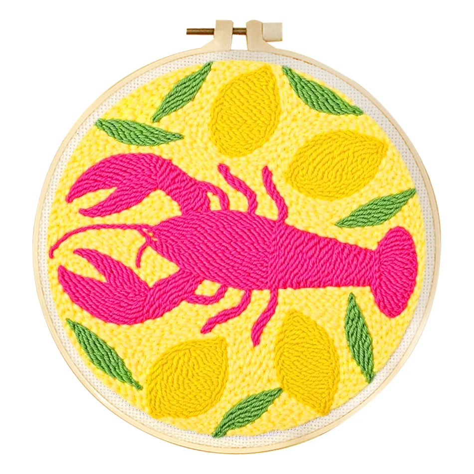 Punch needle embroidery kit with pink lobster, yellow lemons, and green leaves in a wooden hoop.