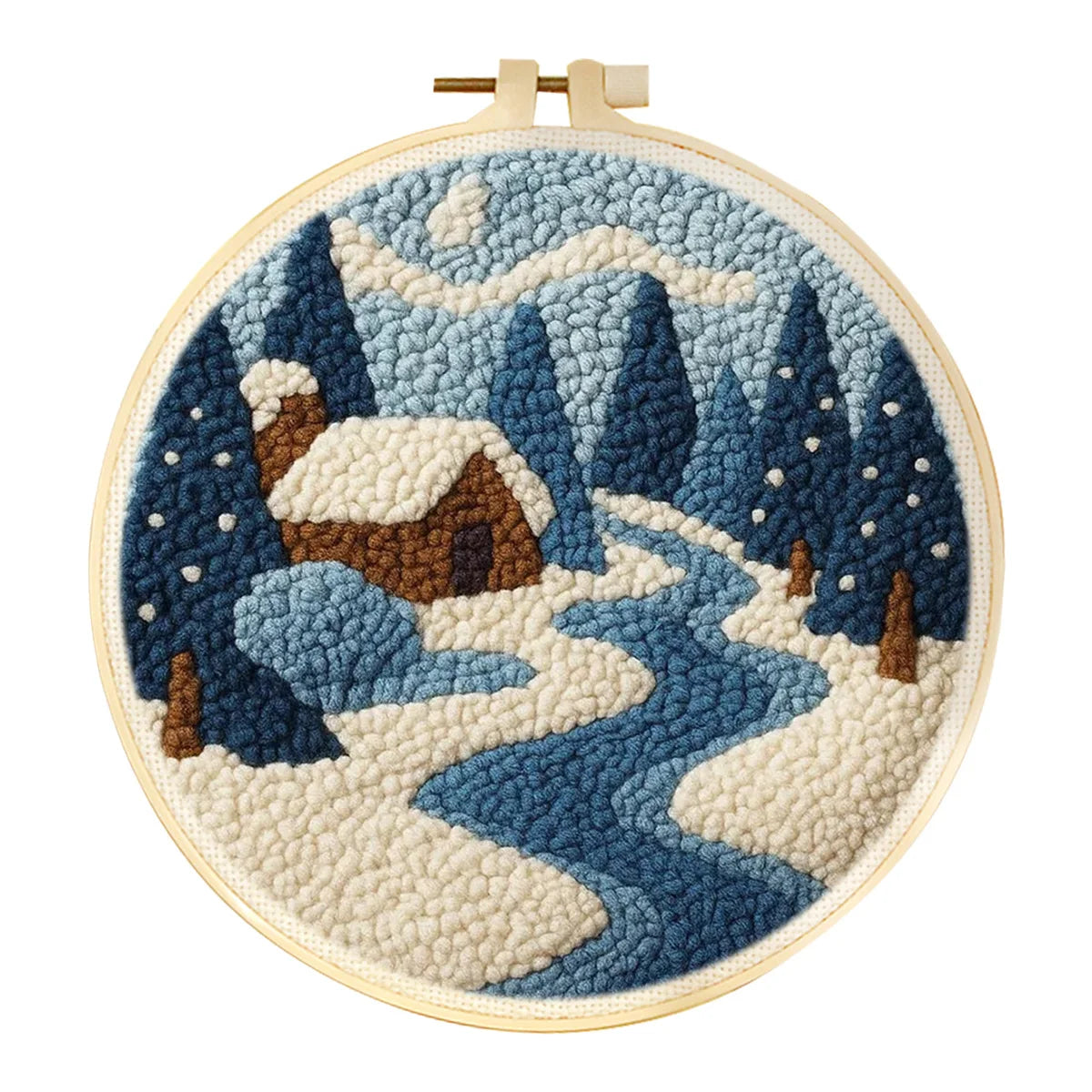Punch needle winter landscape art kit in a wooden hoop, featuring a snowy cabin, trees, and a river.