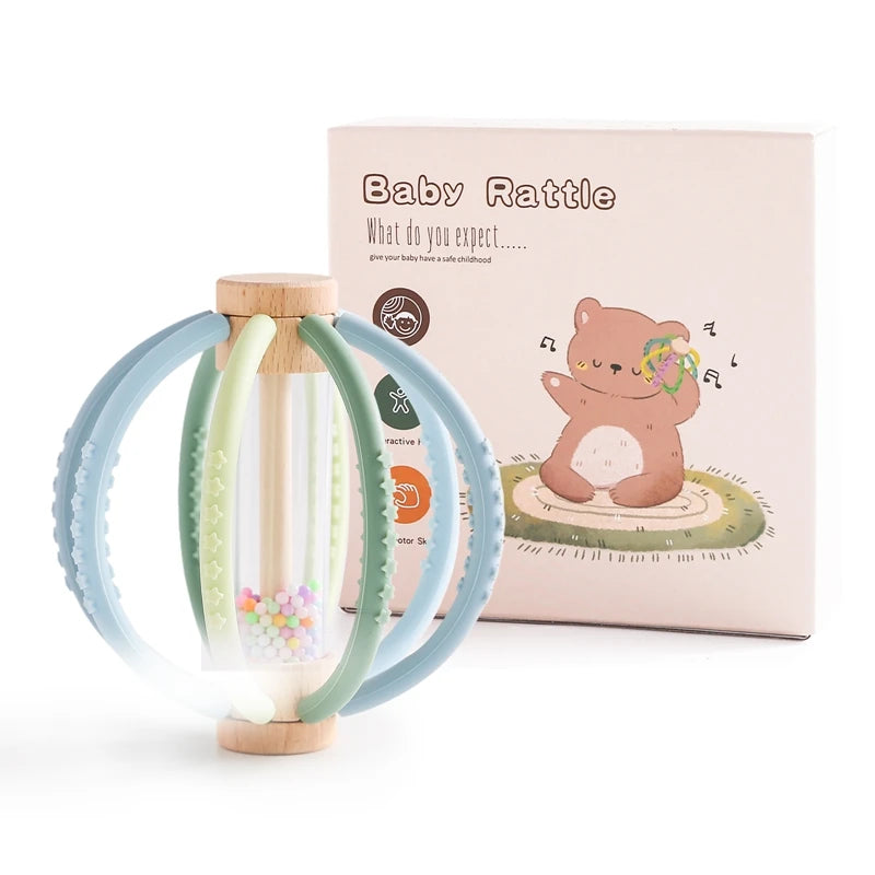Wooden baby rattle with silicone teether rings and rain drum, next to its bear-themed gift box.