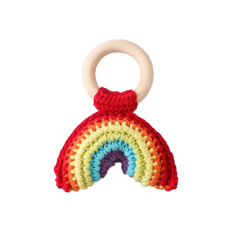 Crochet rainbow baby rattle with a natural wooden ring, soft cotton, and vibrant colors.