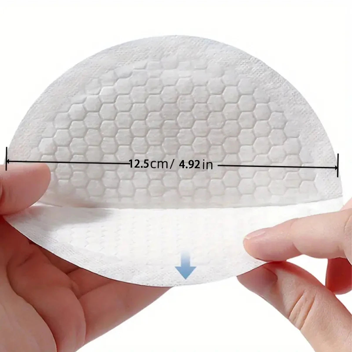 White disposable nursing pad with honeycomb texture, held by hands, showing 12.5cm / 4.92in diameter.