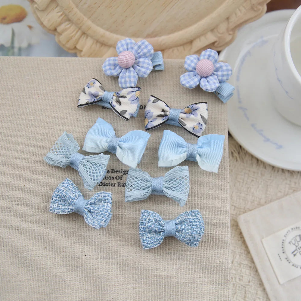 Set of 10 blue and white fabric hair clips for babies and girls, featuring bows and floral designs.