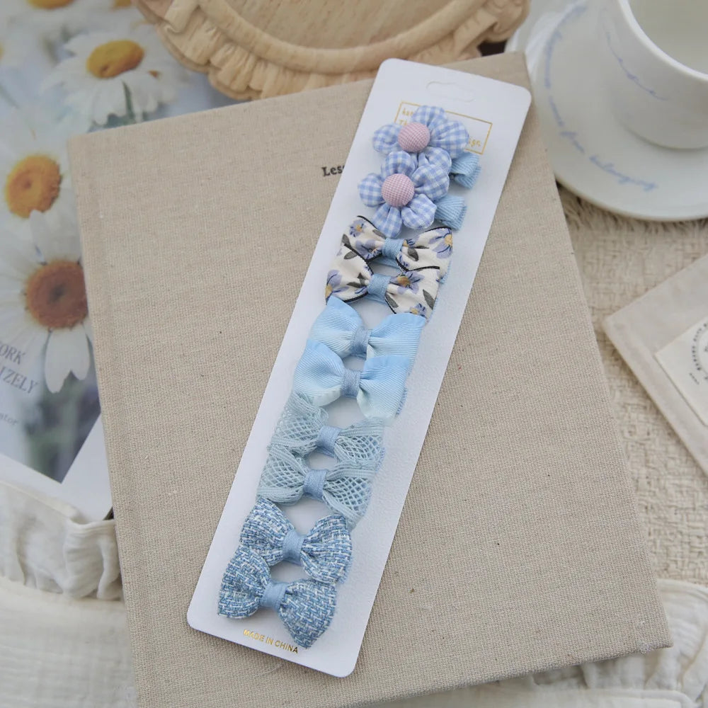 Set of 6 blue and white fabric hair clips for babies and girls, featuring bows and a flower design.