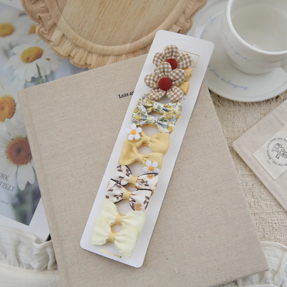 Set of 10 soft cotton hair clips for babies and girls, featuring yellow bows and floral designs.