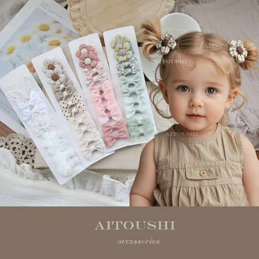 Adorable baby girl wearing two checkered flower hair clips, with four sets of soft fabric bow and flower clips displayed.