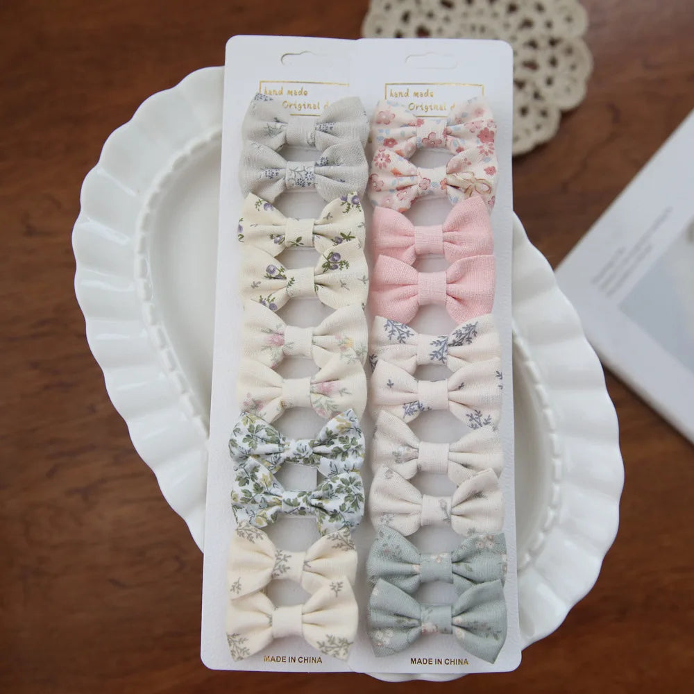 Set of 10 soft cotton hair clips for babies and girls, featuring delicate bows in various floral and solid pastel designs.