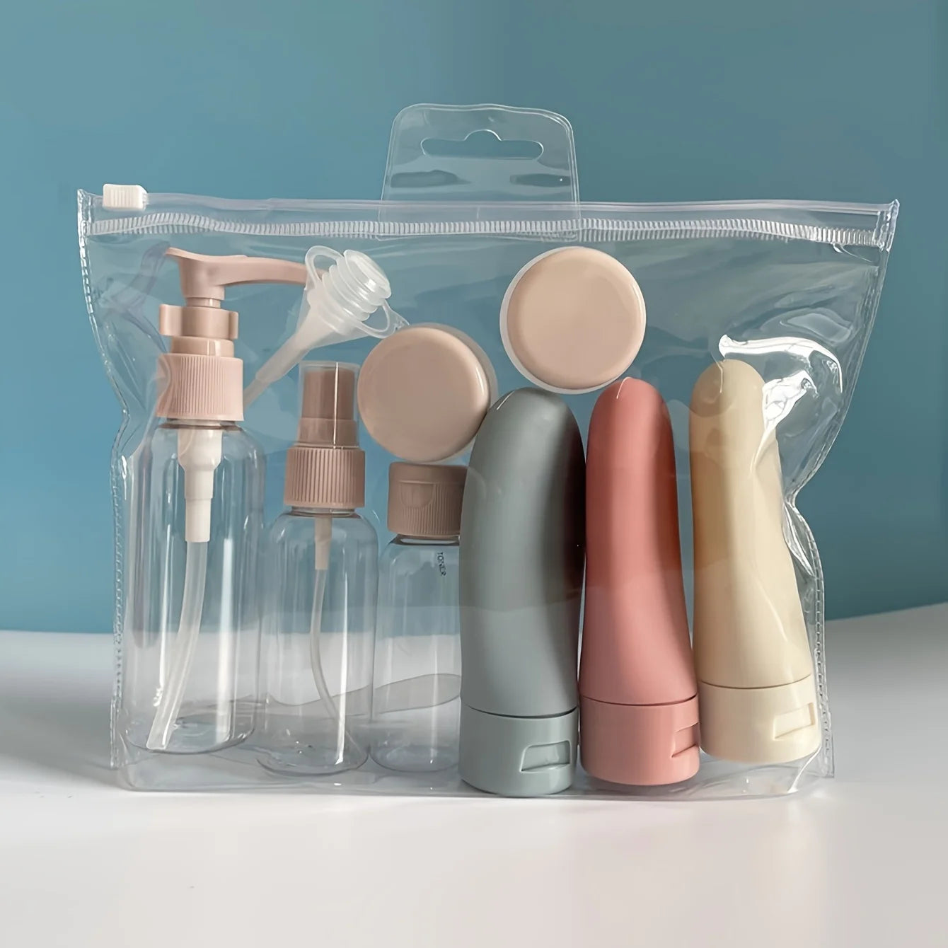 11-piece reusable travel bottle set in a clear plastic bag, featuring various sizes of clear and pastel-colored containers.