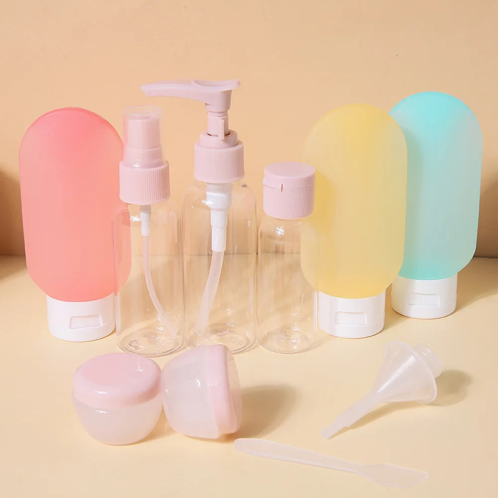 11-piece travel bottle set with clear and colorful refillable containers, pink caps, and accessories.