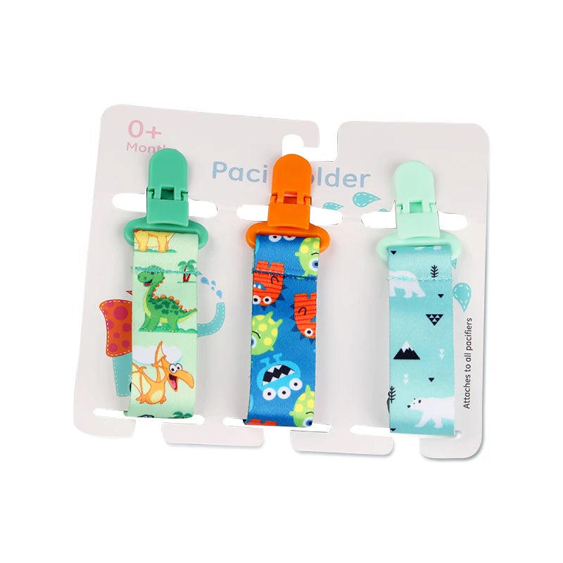 Set of 3 colorful polyester pacifier clips with plastic clasps, featuring dinosaur, monster, and polar bear prints.