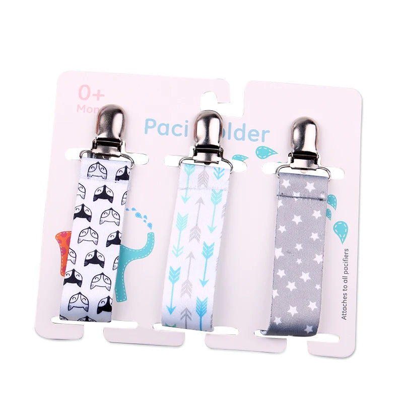 Set of 3 baby pacifier clips with plastic clasps: white with fox print, white with blue arrows, and gray with white stars.