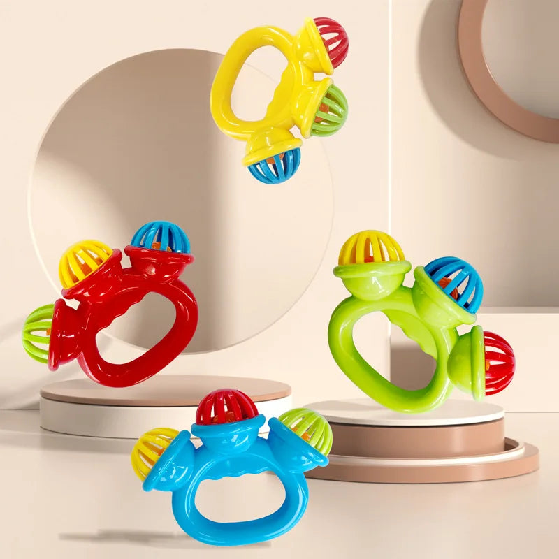 Colorful plastic baby rattles with easy-grip handles and multiple rattling balls, in red, blue, green, and yellow.